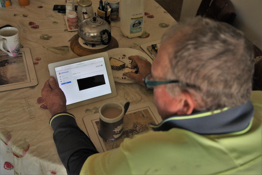 An older man with white hair hold a device showing him water levels, and a lamington.