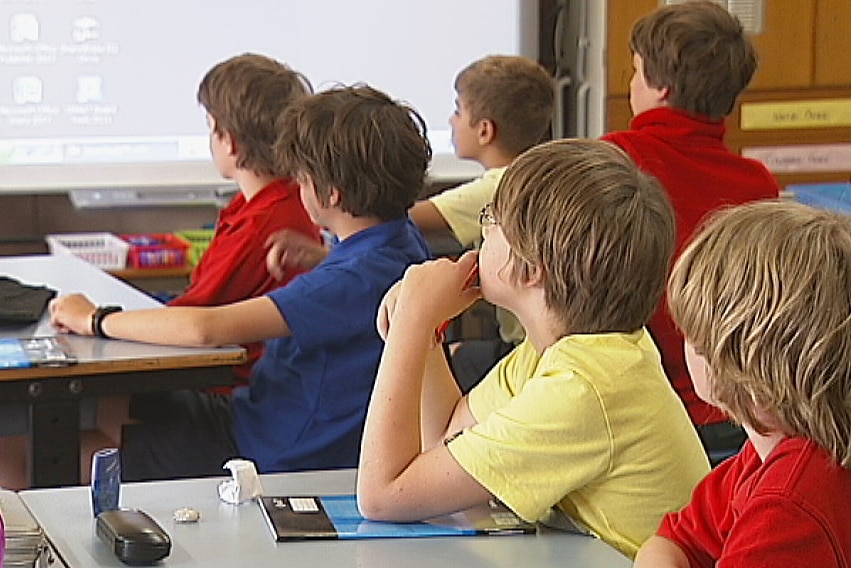 Primary school children look at the front of a classroom