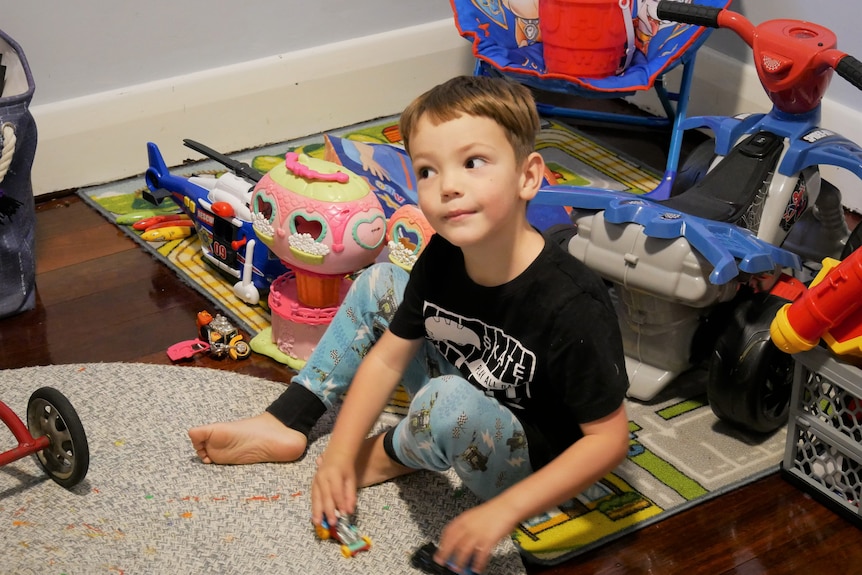4-year-old boy playing with toys on the floor.