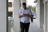 Volunteer firefighter Jordan Dean Ashford, with his head bent over his phone, outside Perth District Court.