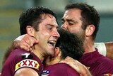 Opening try ... Cooper Cronk celebrates his four-pointer with his Maroons team-mates