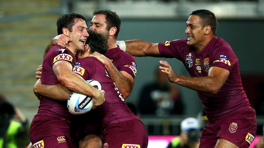 Opening try ... Cooper Cronk celebrates his four-pointer with his Maroons team-mates