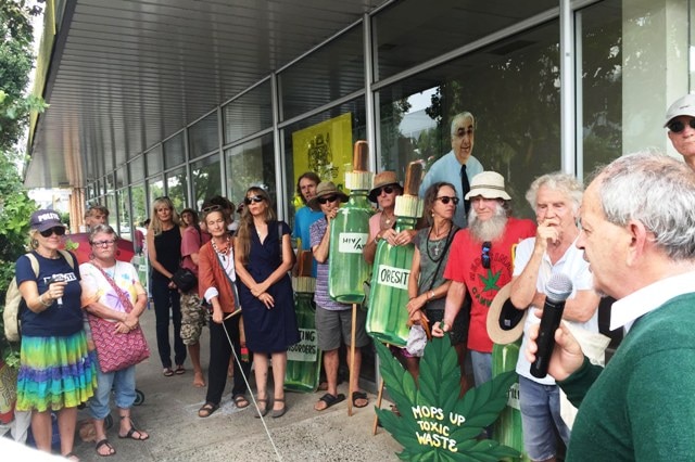 Protesters gather outside the office of Lismore MP Thomas George