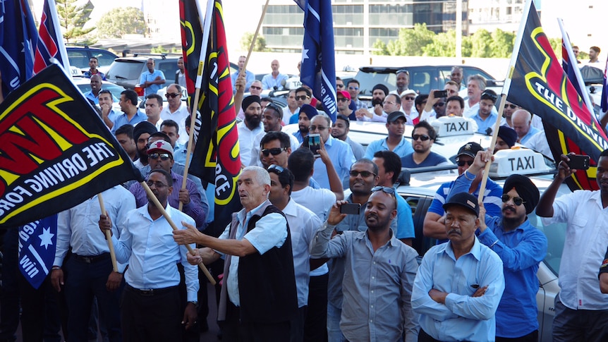 Taxi drivers wave flags in rally against Uber at Parliament
