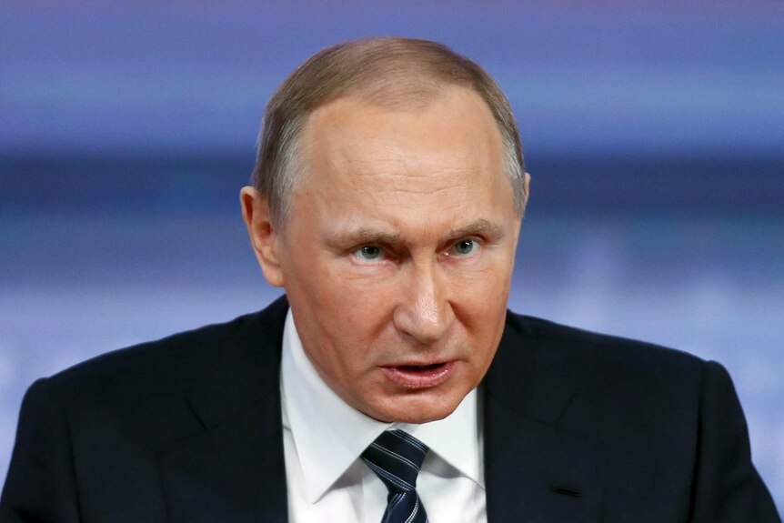 Russian President Vladimir Putin leans forward while speaking.