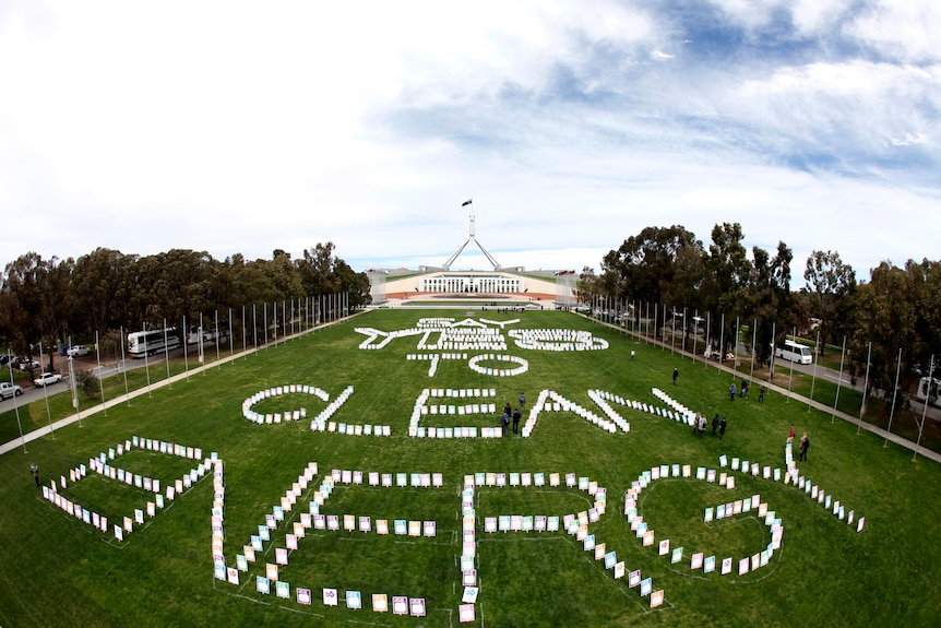 Carbon tax supporters share their message on the lawns of Parliament House (AAP: Lukas Coch)
