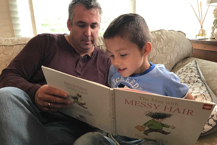 Father and son reading a book