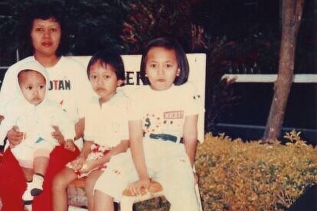 Dea Winnie Pertiwi sitting with her sisters and mother on a park bench.