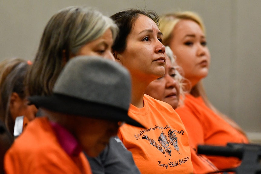 First Nations women appear emotional as they hear of the discovery of 215 unmarked graves in British Columbia on July 15, 2021.