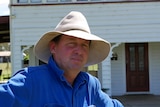 A man in a wide-brimmed hat and farming clothes