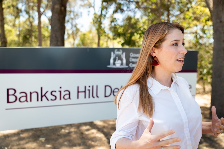Rikki stands in front of Banksia Hill Detention Centre sign 