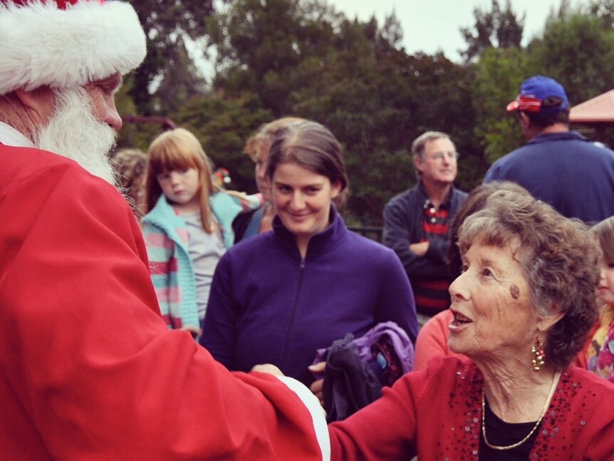 a woman shakes hands with a santa