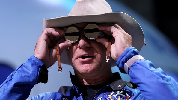 A man in a cowboy hat looks through space goggles