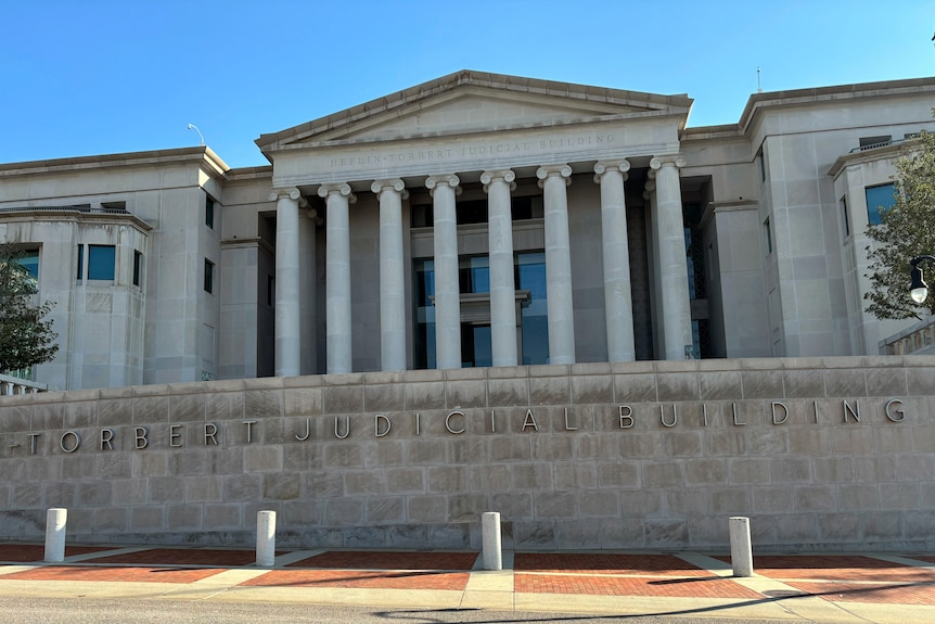 A stone building with eight large columns at its front. 'TORBERT JUDICIAL BUILDING' can be seen on a wall.