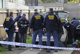 Australian Federal Police officers and forensic police inspect a car at a house in View St, Glenroy