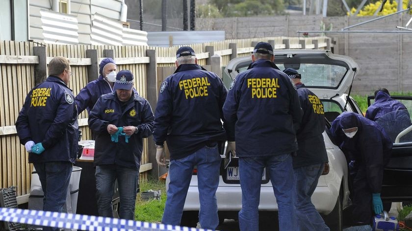 Australian Federal Police officers and forensic police inspect a car at a house in View St, Glenroy