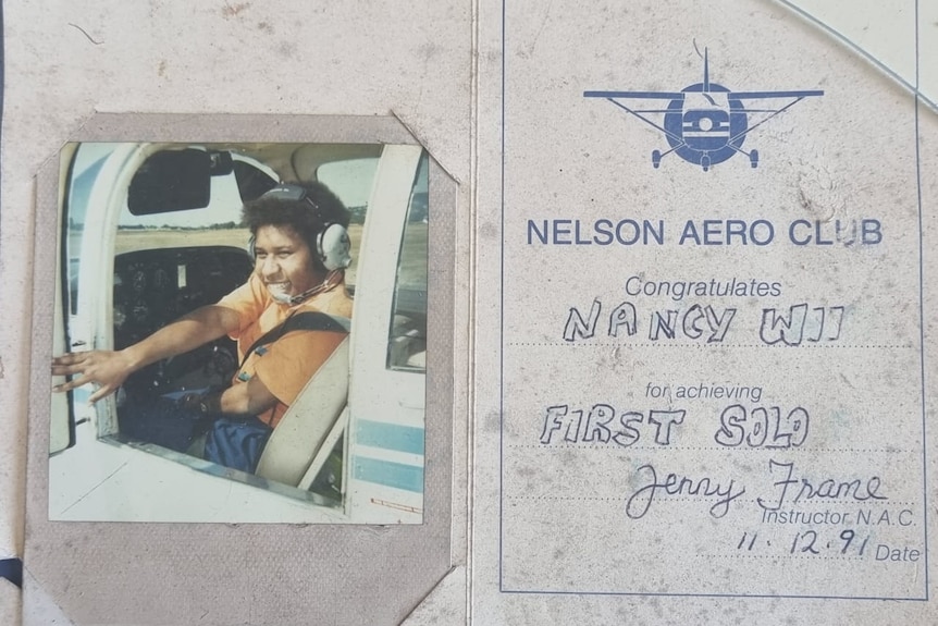 A picture of a woman in a helicopter next to a certificate from Nelson Aero Club.