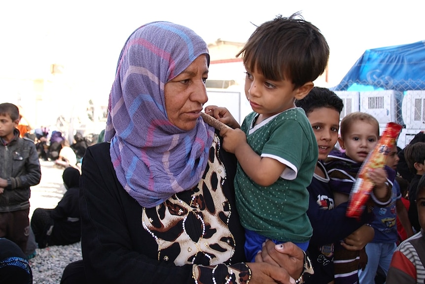 A mother holding her young son in the Debaga camp, North Iraq.