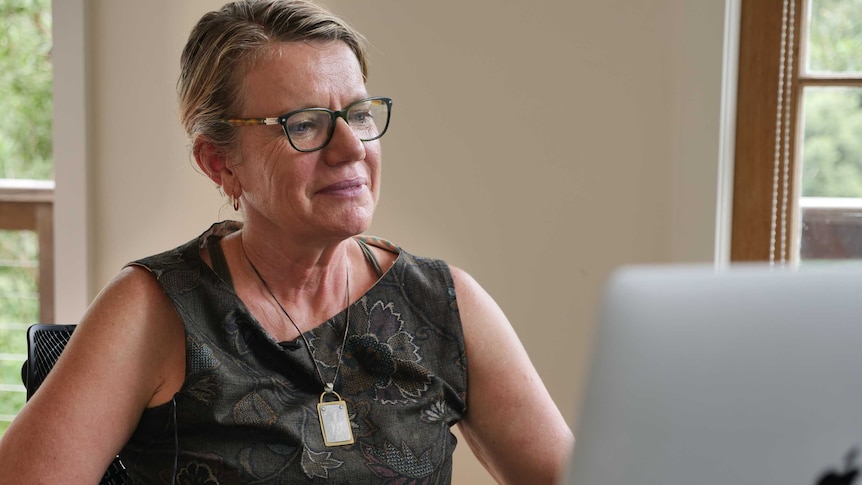 A former academic and rural health researcher sits at her desk in Bellingen