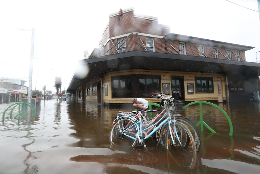 A street flooded in front of a building.