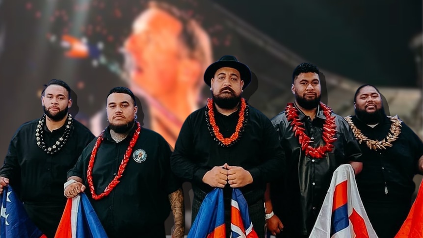 Five Pacific Island men stand proudly in front of an image of Coldplay's Chris Martin. 