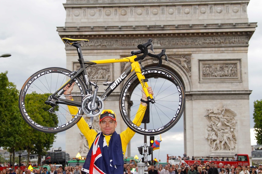 Cadel Evans holds his bicycle in front of the Arc de Triomphe after winning the Tour de France