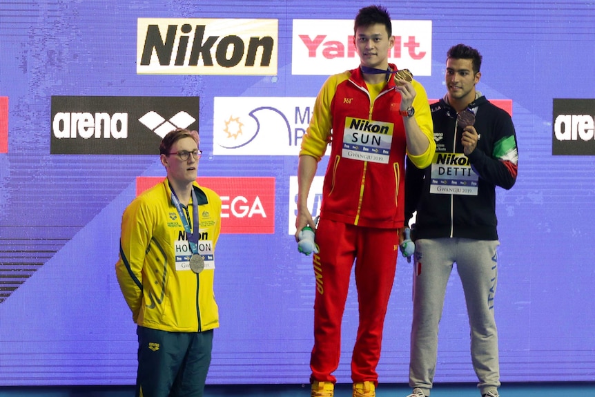 Australia's Mack Horton stands off the podium as Chinese swimmer Sun Yang and Italy's Gabriele Detti hold their medals.