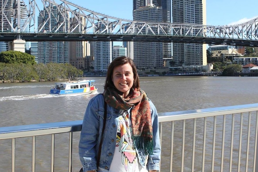 A picture of a woman standing in front of Brisbane's Storey Bridge