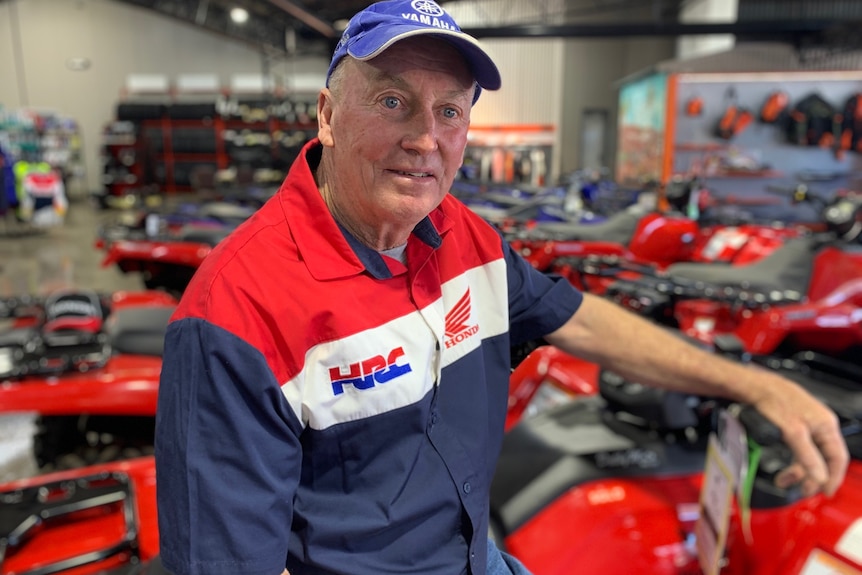 Photo of man in front of quad bike.