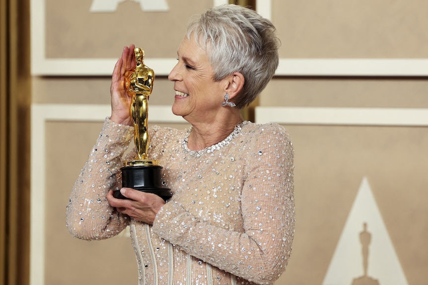 Jamie Lee Curtis looking left holding an oscar