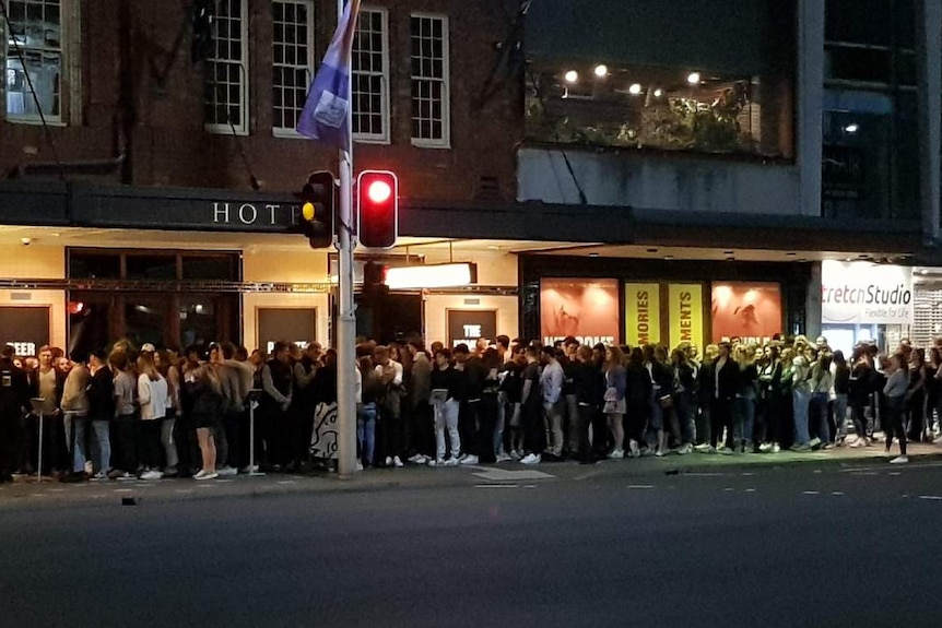 A queue of people outside a hotel