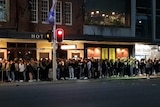 A queue of people outside a hotel