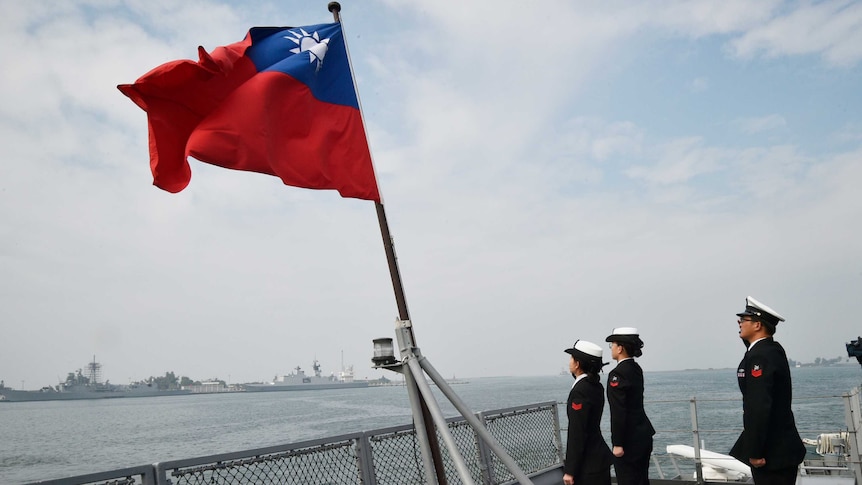 Taiwanese sailors salute the island's flag on the deck of the Panshih supply ship after taking part in annual drills.