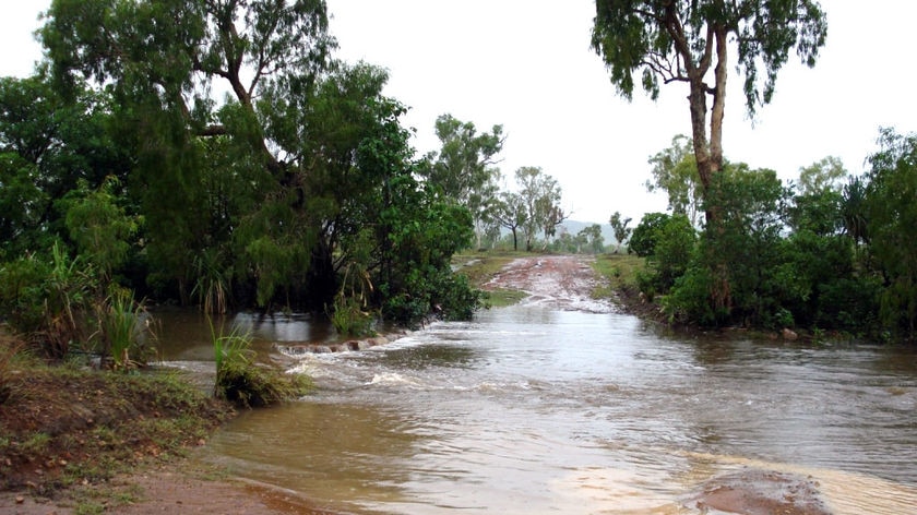 Rising floodwaters begin to cover a dirt road just outside the town of Kalumburu