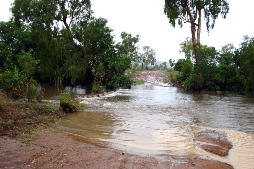 Rising floodwaters begin to cover a dirt road just outside the town of Kalumburu