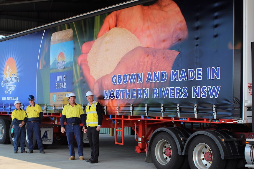 Employees next to large truck that has a low Gi sugar pack on it. 