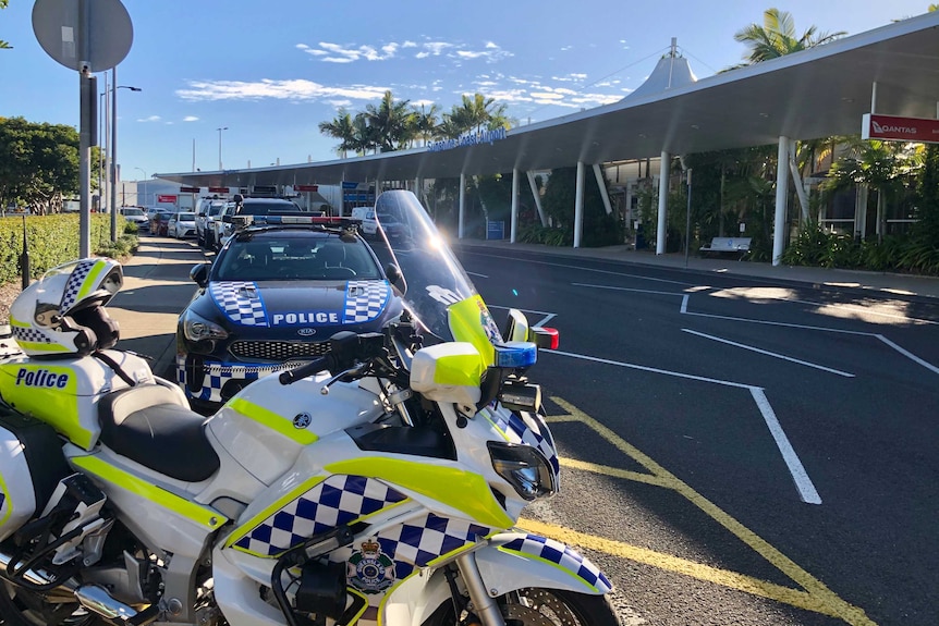 A police motorbike and cars line the street outside the Sunshine Coast Airport on 6 June, 2020.