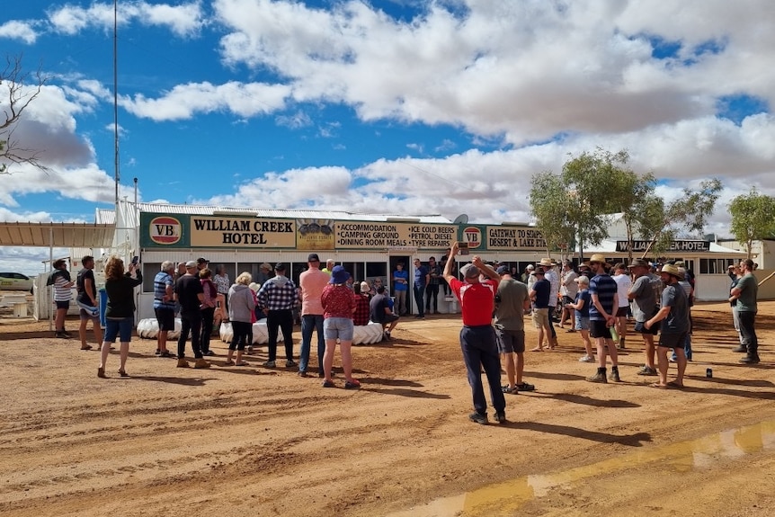 People standing and having a meeing outside an outback hotel.