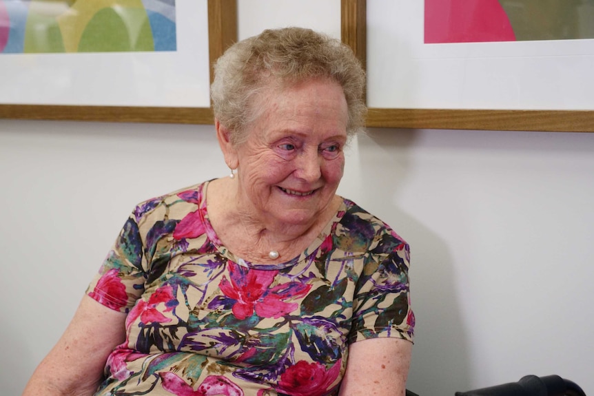 Elaine Madden wearing a colourful shirt and smiling.