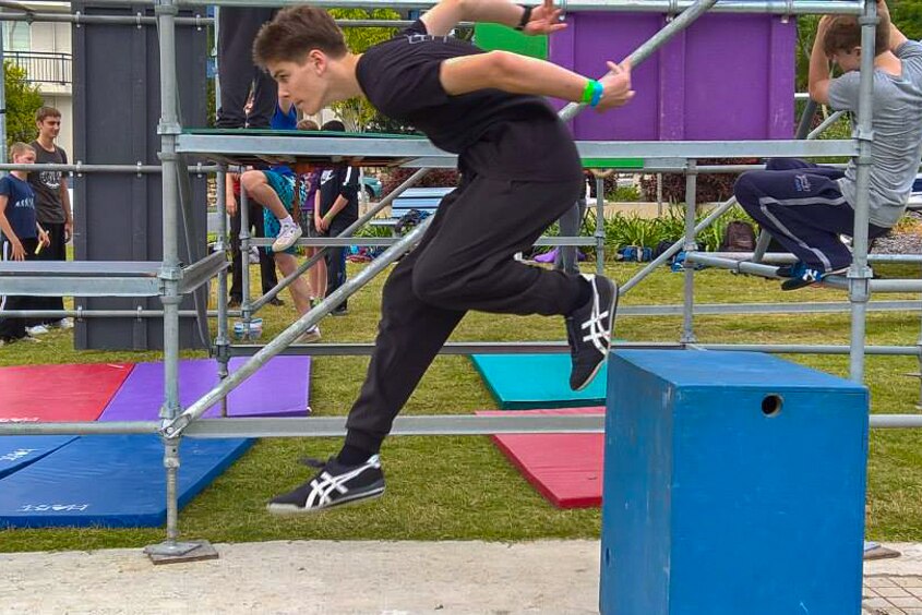 One of the Brisbane Parkour Association members jumps from a block to the ground as part of his practise.