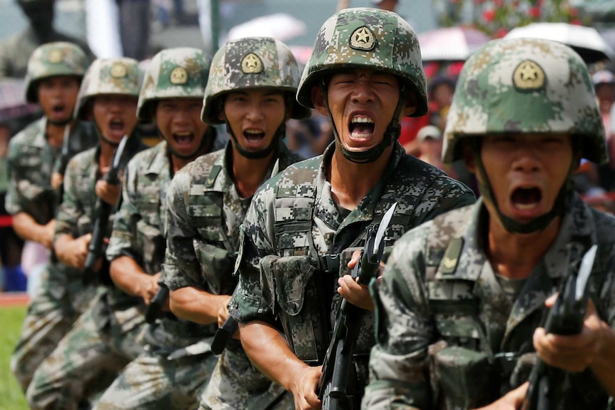 A group of Chinese soldiers shouting while grasping bayonets