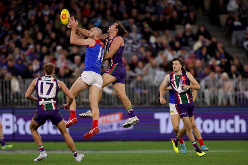 Dockers defender Alex Pearce spoils Max Gawn's marking attempt from behind as other Dockers players look on.