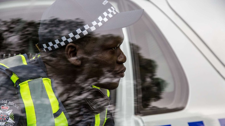 Constable Kur Thiek seen through the window of his police car.