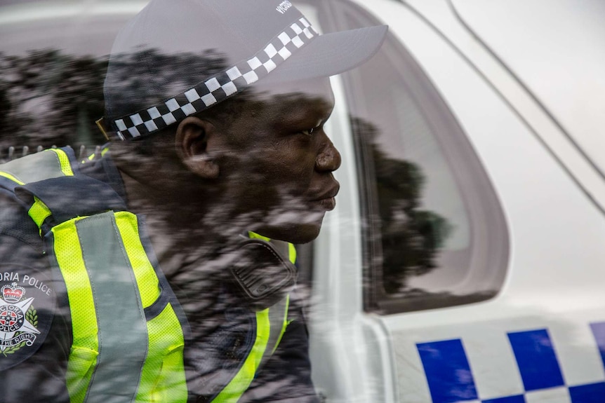 Constable Kur Thiek seen through the window of his police car.