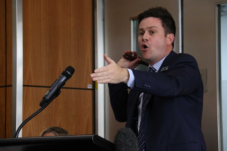 An auctioneer wields a hammer.