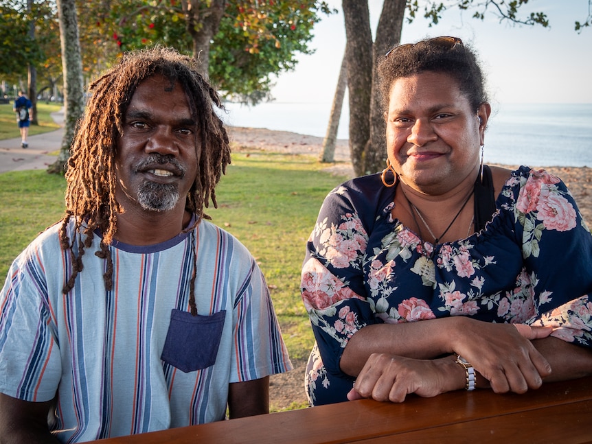 An Indigenous man with dreadlocks and a grey goatee with an Indigenous woman wearing a floral dress