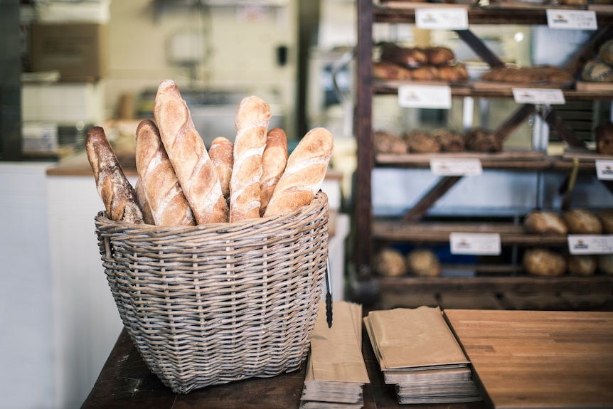 A basket of baguettes on a bakery counter