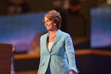 Nancy Pelosi smiles at the audience as she walks on stage