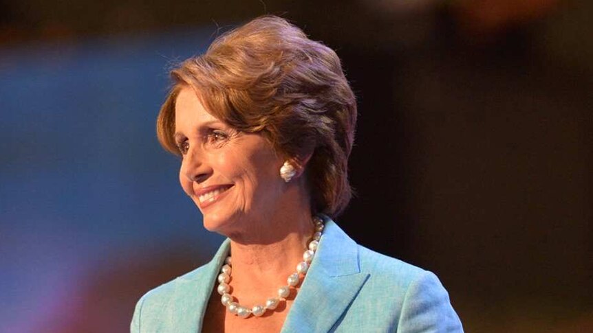 Nancy Pelosi smiles at the audience as she walks on stage