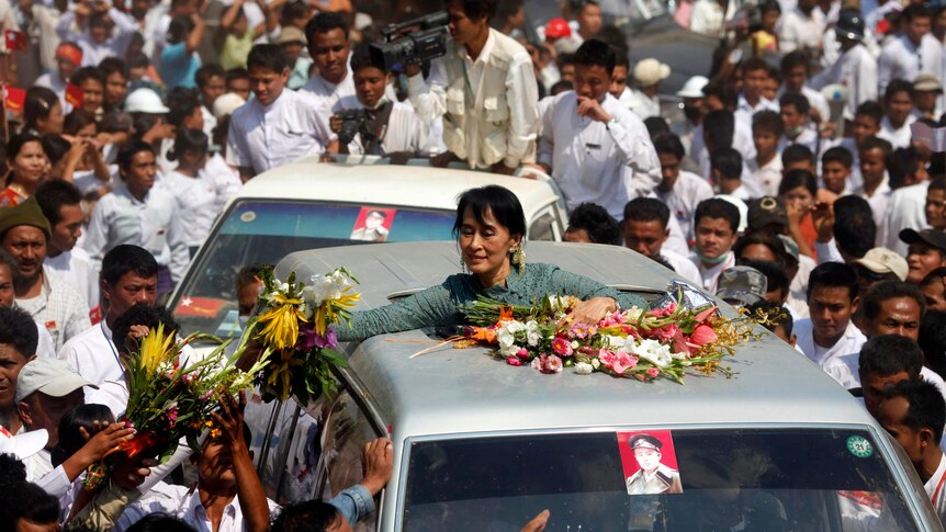 Aung San Suu Kyi receives flowers from supporters in the village of Yae Phu, Burma.